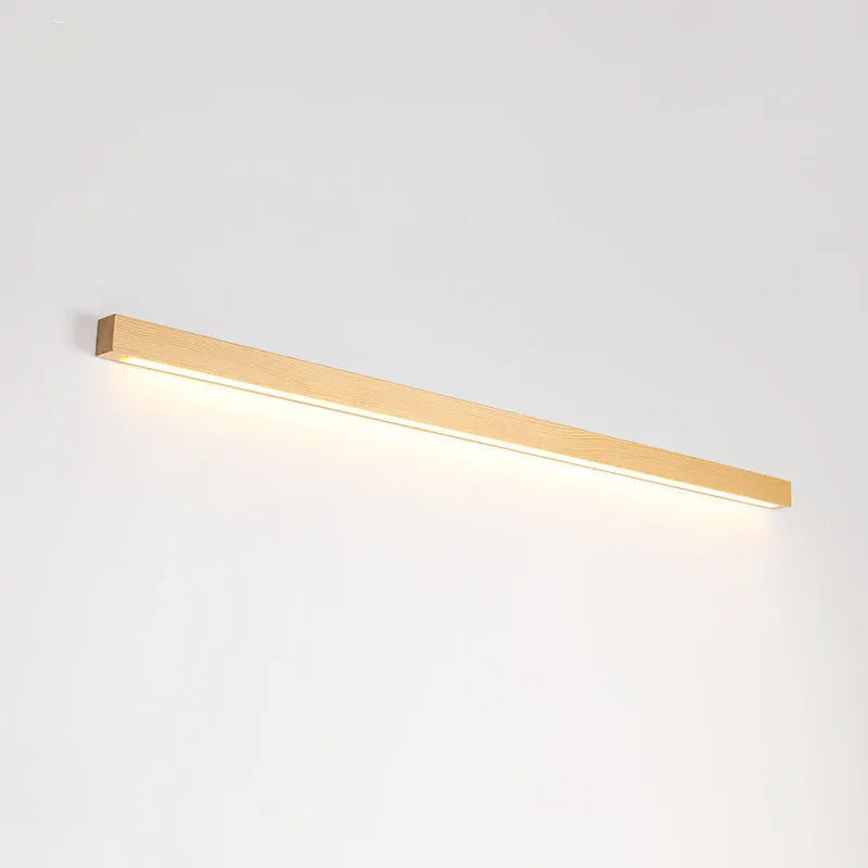 Slim walnut-coloured wooden strip LED wall lamp in three length options on a white wall.