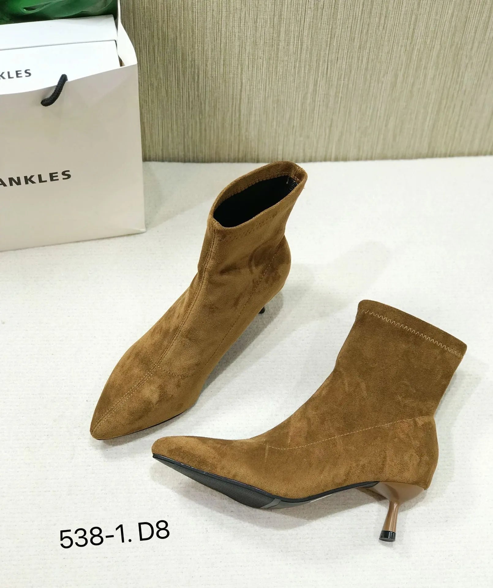 Black pointed toe ankle boots with stiletto heels and mid-calf length