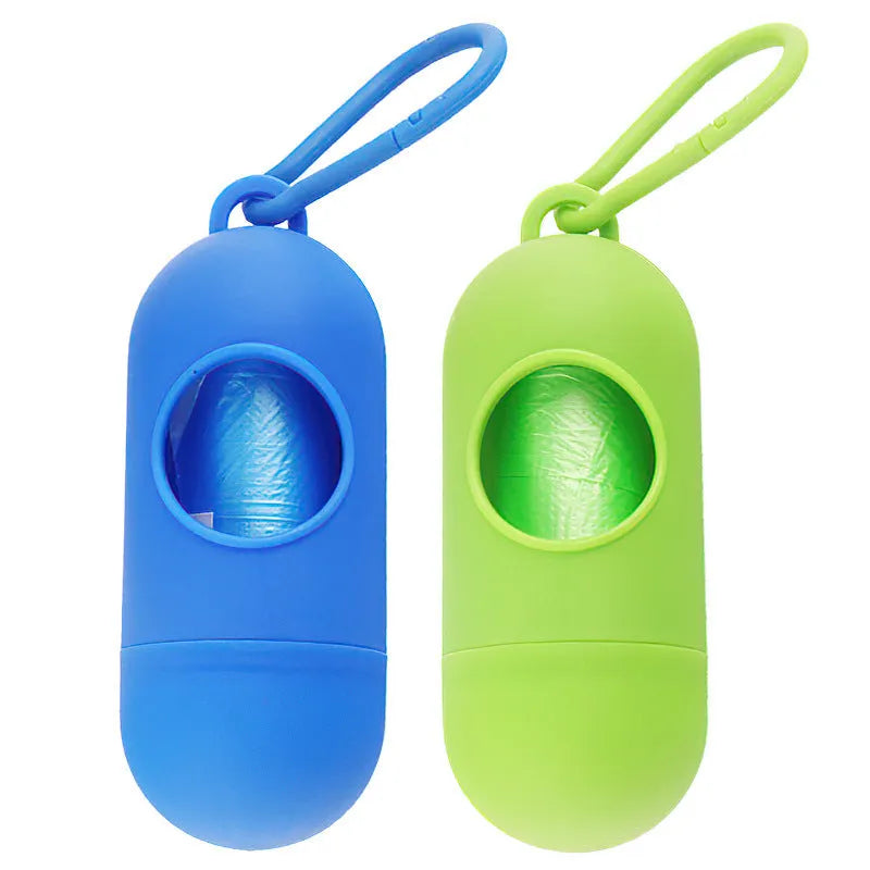 Compact black dog poop bag holder with hook and Velcro strap, shown attached to a pair of trousers.