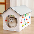 House-shaped cat scratch board with integrated bell ball and plastic tunnel forming multifunctional cat furniture