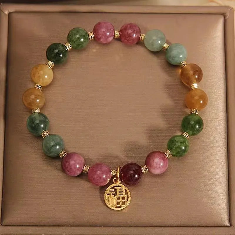 Natural colour tourmaline bracelet with floral beads and geometric design on wrist