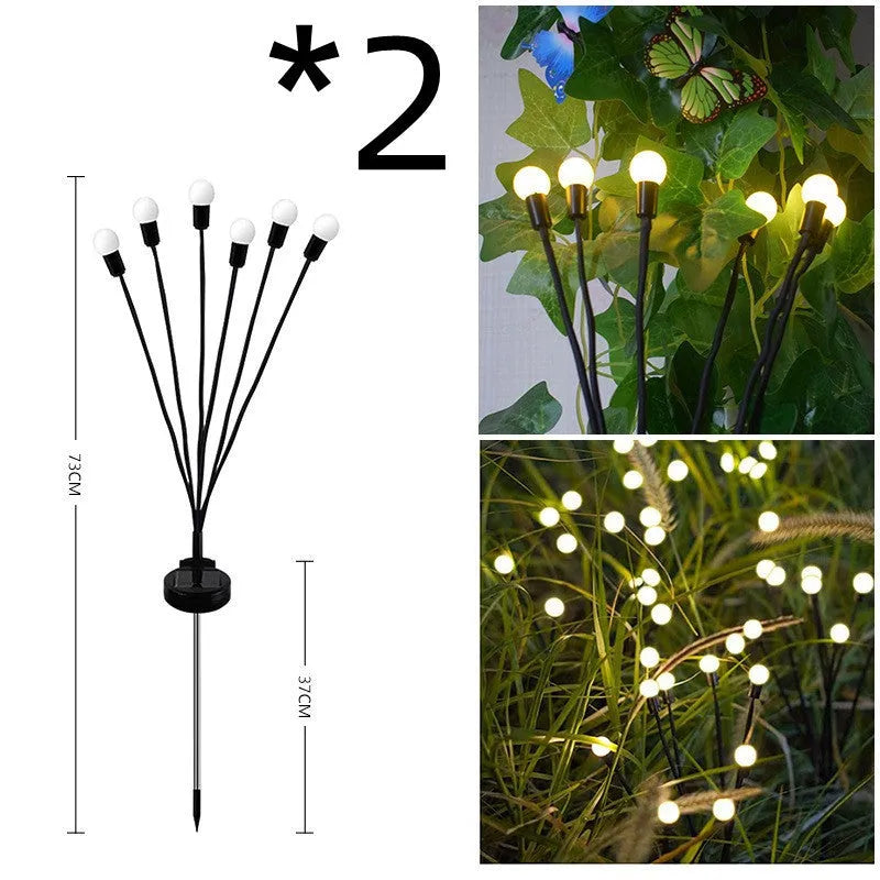 Solar-powered LED firefly lawn light with ground stake inserted in grass