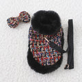 Dog wearing classic cloak with chest strap and attached hand holding rope
