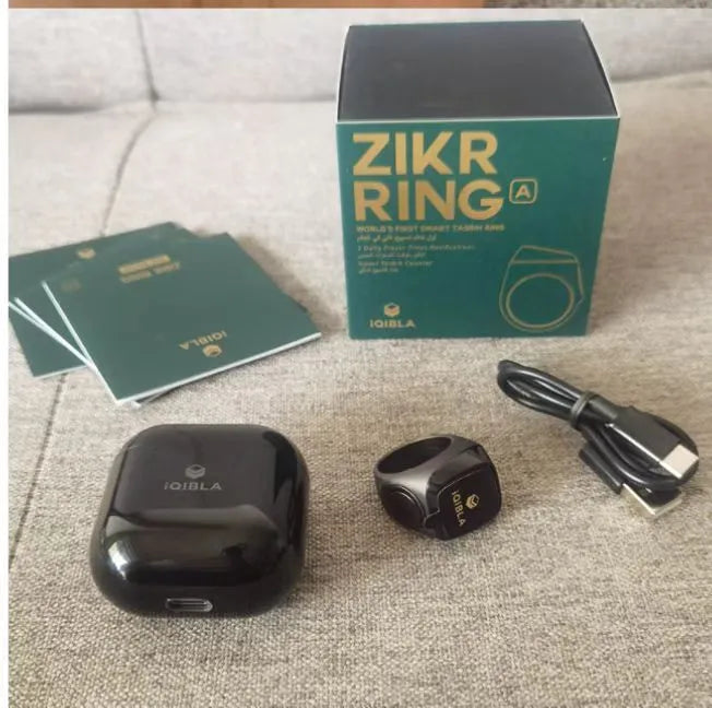Zikr1 smart Islamic prayer ring in silver on a hand, showing its OLED display and single button.