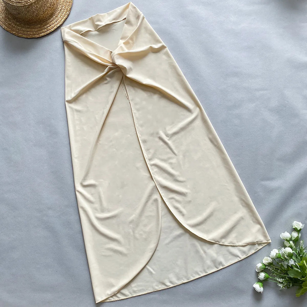 Women's brown one-piece swimsuit with matching beige skirt laid flat