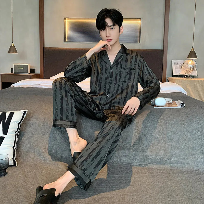 Men's black striped Ice Silk long sleeve V-neck pajama top and thin trousers set laid flat.