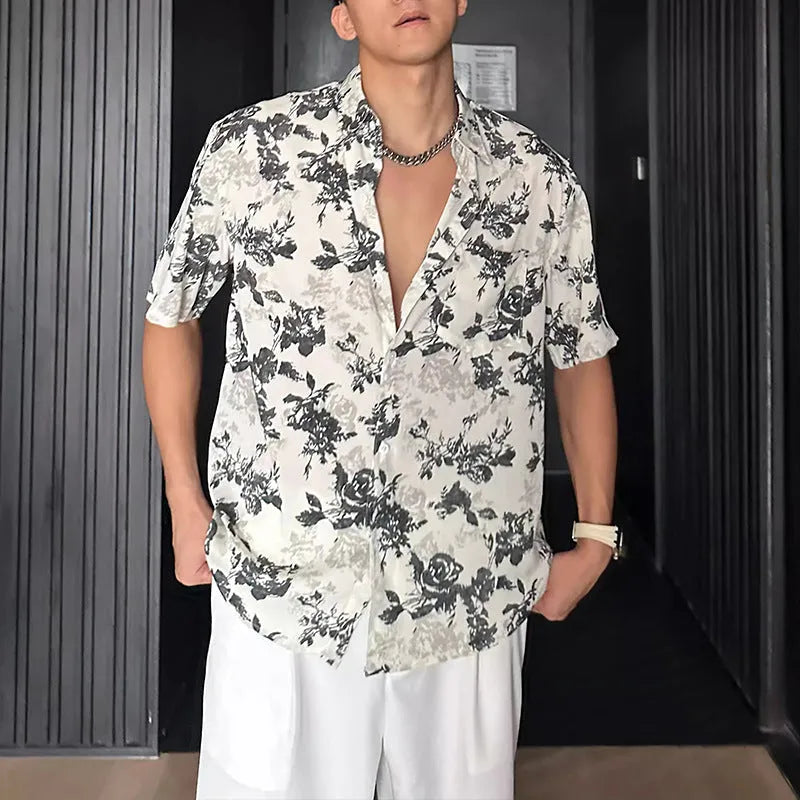 Man's loose fit black short sleeve shirt with floral pattern, worn open in cardigan style.