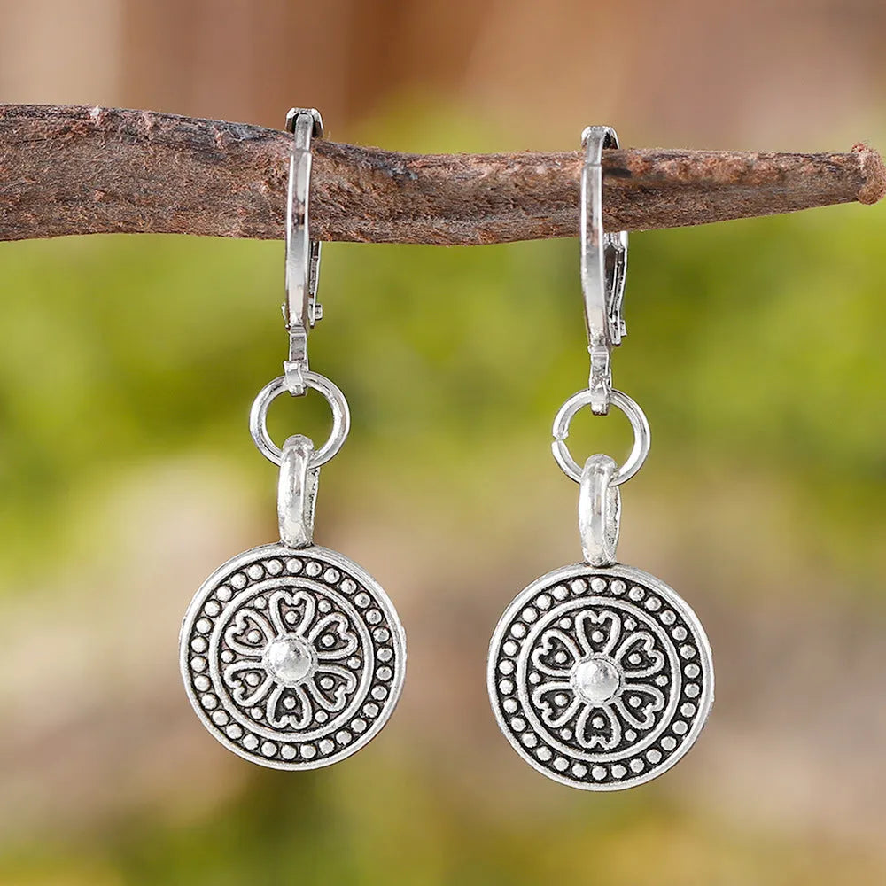 A pair of geometric zinc alloy earrings with a round distressed ethnic print in Bohemian retro style.