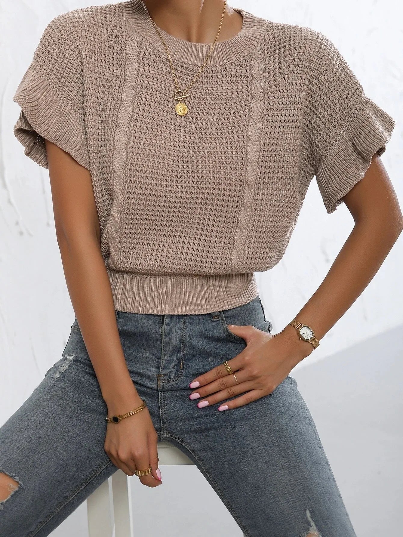 White loose knitted women's pullover sweater with ruffled short sleeves and a textured 3D pattern.