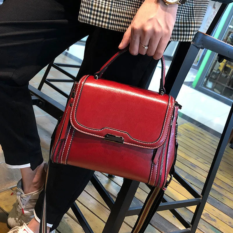 Women's brown genuine oil wax leather messenger bag showing front view with double straps and visible sewing details.