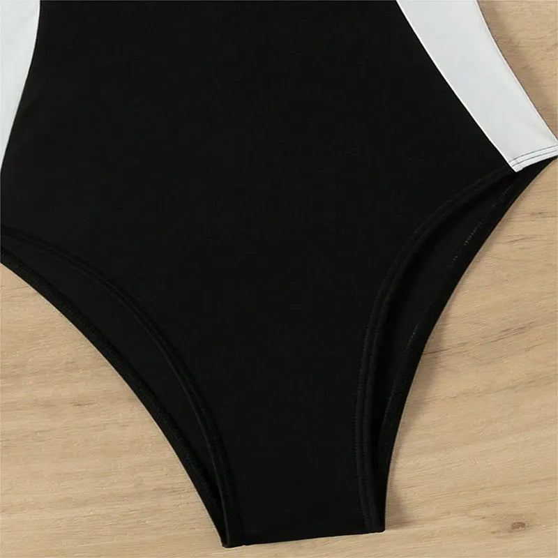 Black and white women's one-piece swimsuit with spaghetti straps and slim fit design