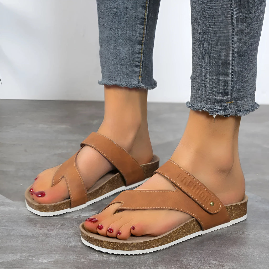 Thick-soled blue flip-flops with flat toe ring design on beach background