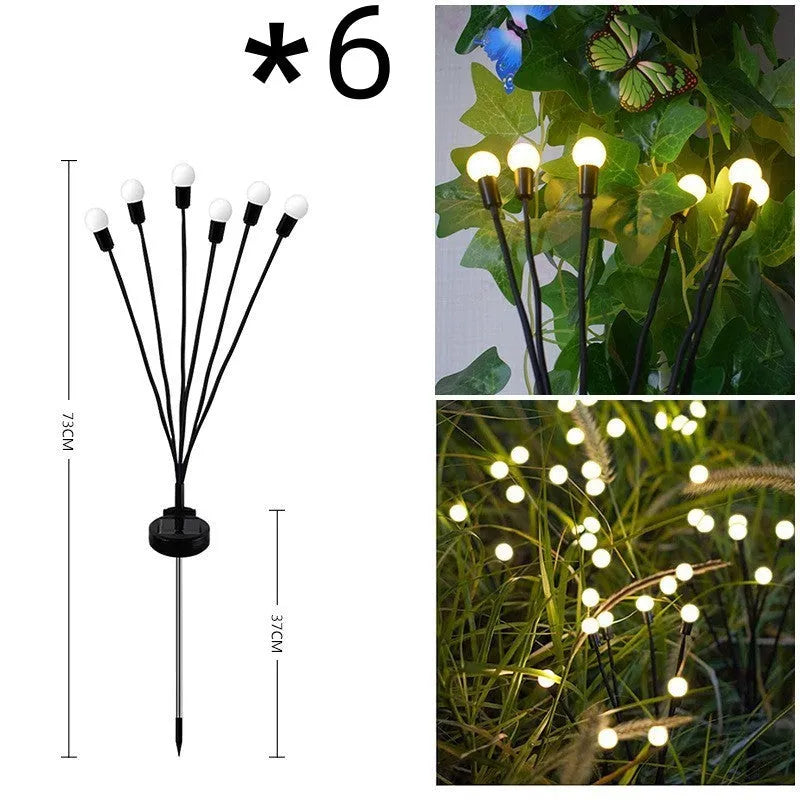 Solar-powered LED firefly lawn light with ground stake inserted in grass