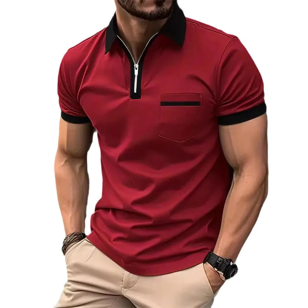 Man wearing a grey and navy blue casual t-shirt with a chest pocket and silver zip decoration detail.