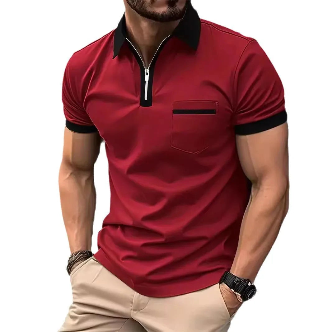 Man wearing a grey and navy blue casual t-shirt with a chest pocket and silver zip decoration detail.