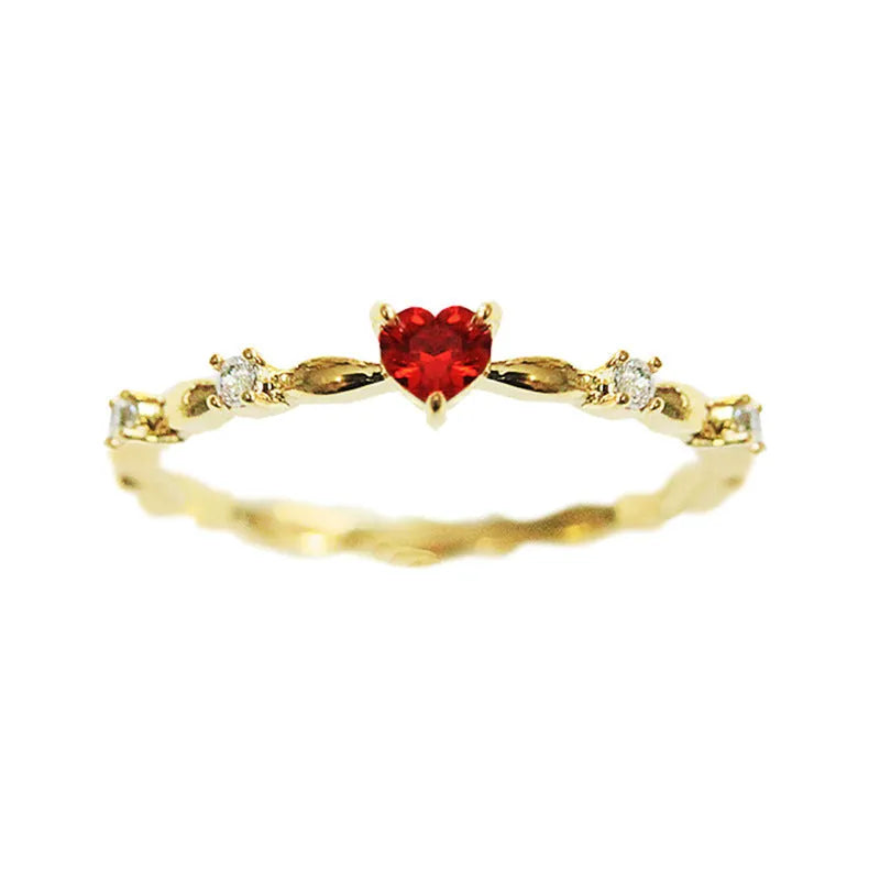 Gold tone peach heart ring with zircon stone centre on finger