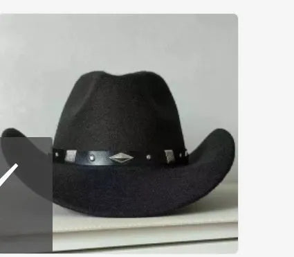 Brown leather velvet curved edge Western cowboy hat with a conical crown on a table.