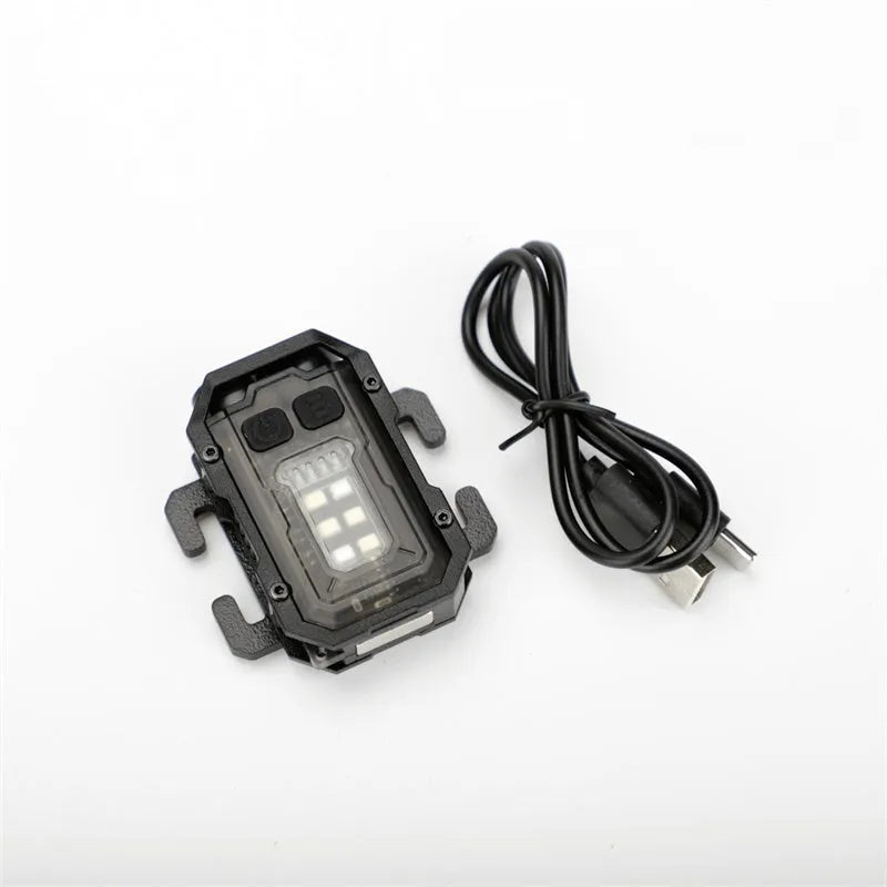 Portable mini tactical warning flashlight with USB charging cable on a backpack strap.