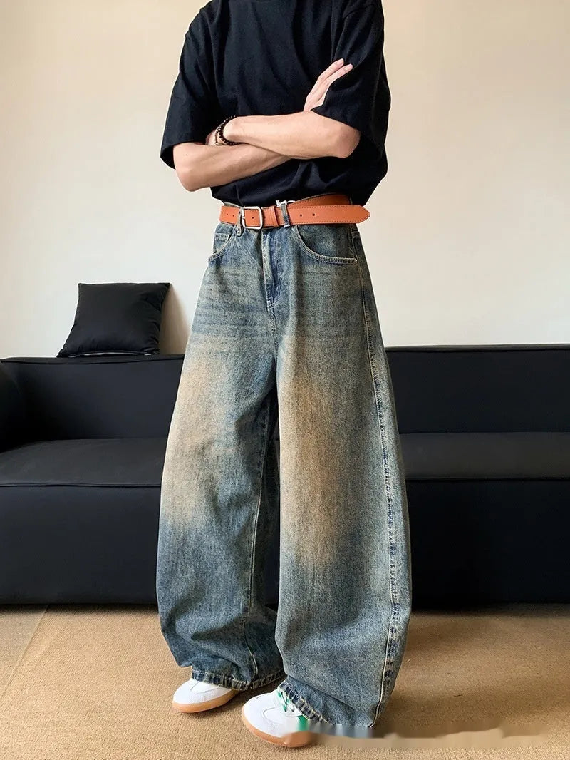 Man wearing retro blue distressed wide-leg denim trousers with a slimming fit.