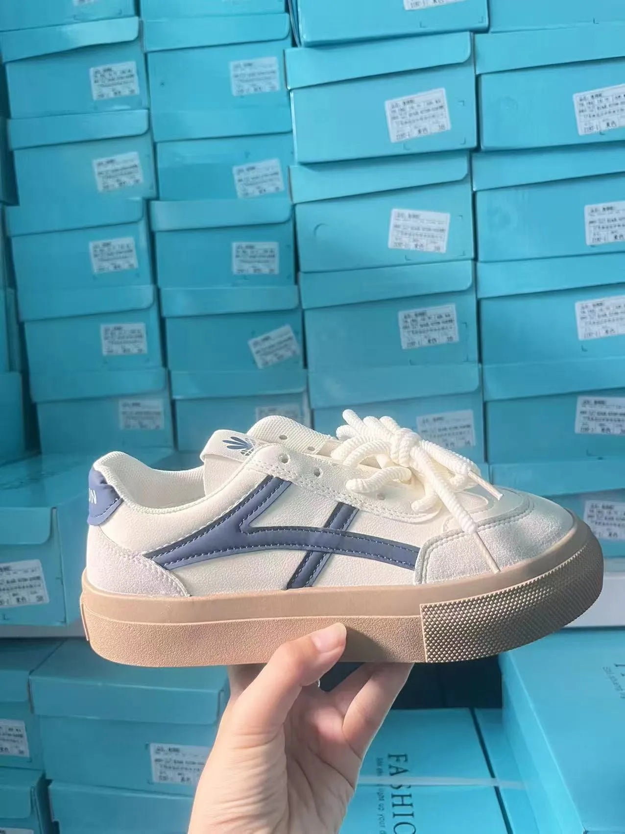 Low top blue board shoes with round toe and flat rubber sole on white background