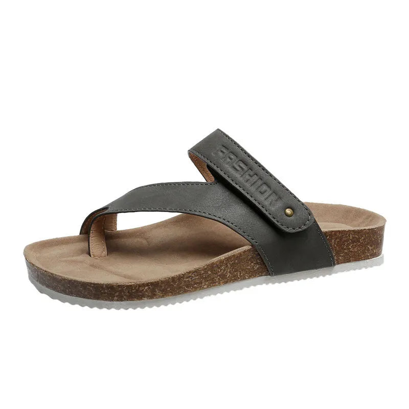 Thick-soled blue flip-flops with flat toe ring design on beach background