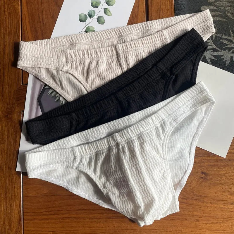 Men's solid colour cotton triangle briefs in mid-waist style, shown in apricot and black colour options.