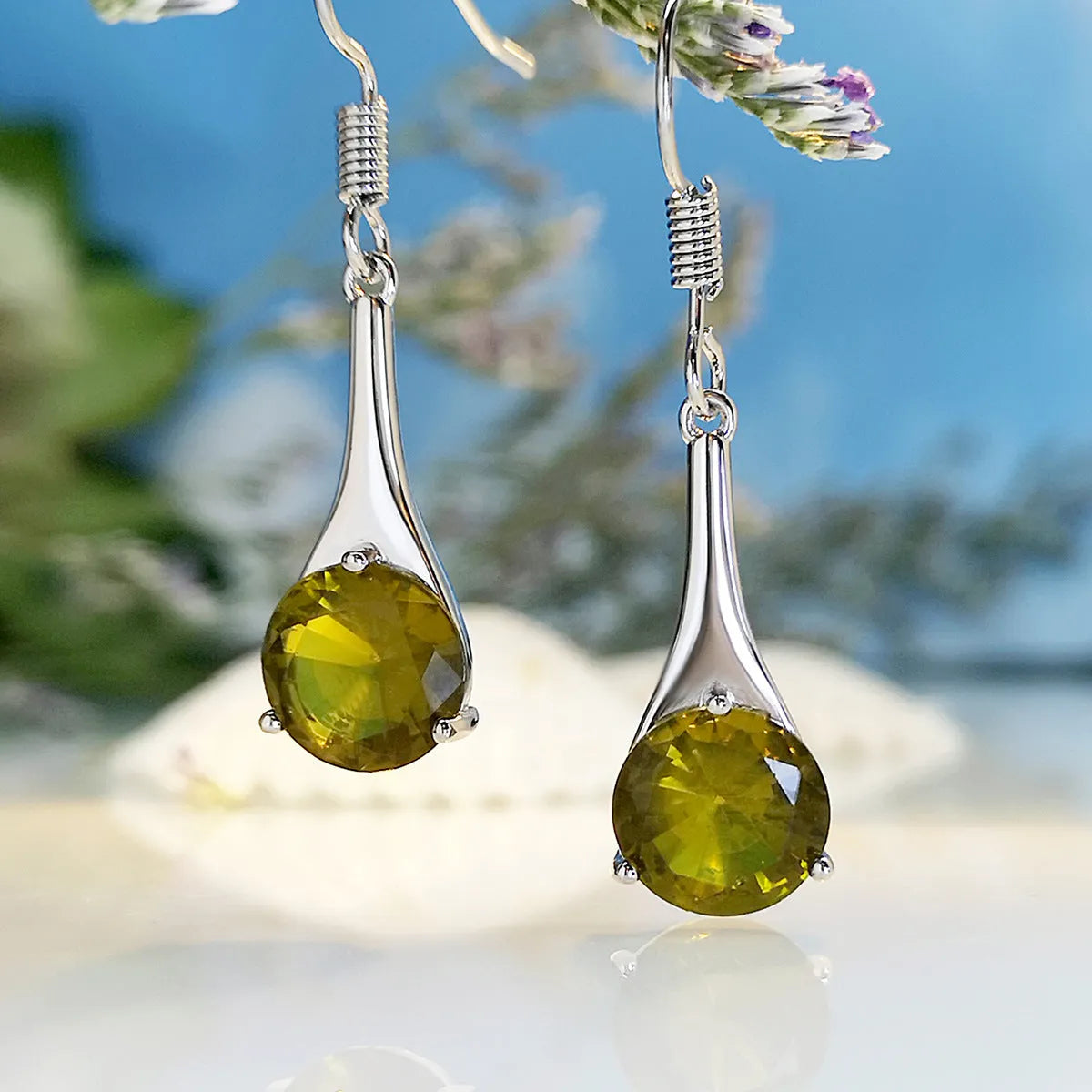 Olive green topaz coloured alloy drop earrings in a water drop shape on a white background.