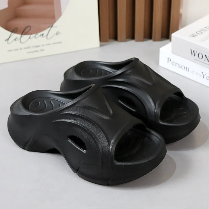 Women's white thick-soled EVA slippers with rounded toe on a sandy beach.