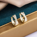 Geometric earrings with copper construction and 14K yellow finish featuring zircon sparkle treatment