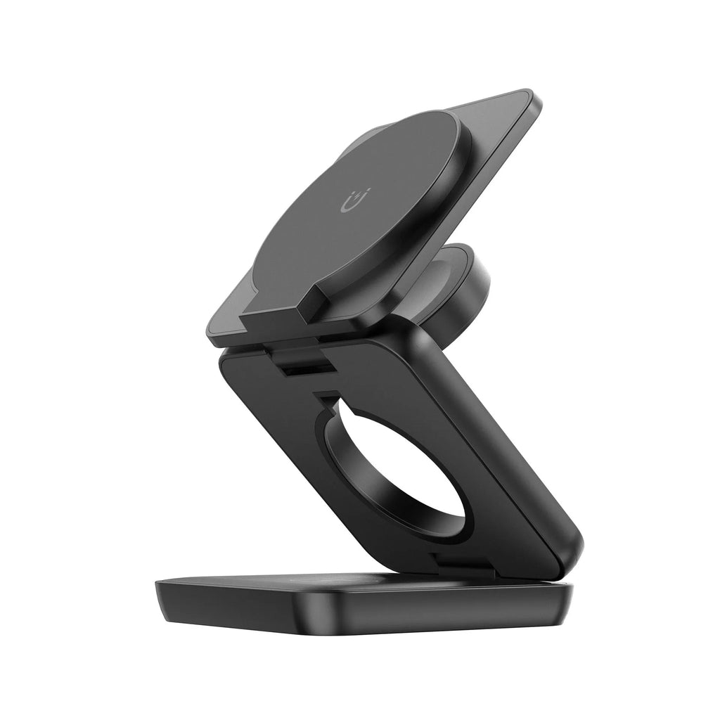 White foldable magnetic wireless charging phone stand on a wooden desk next to a mobile phone.