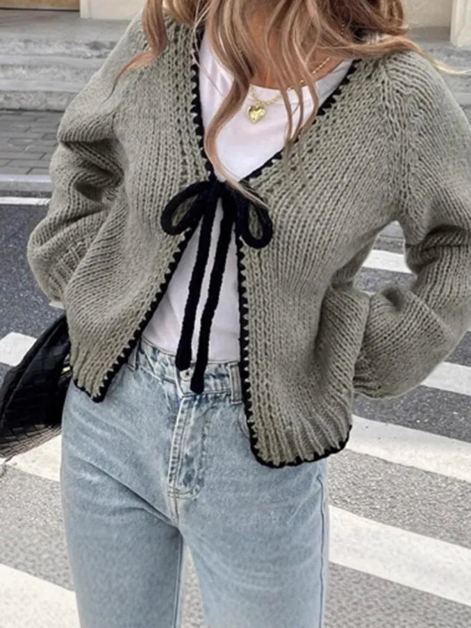 Gray lace-up cardigan sweater with long sleeves and crocheted flower decoration on the front.