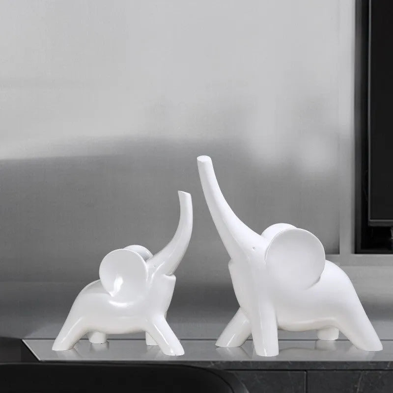 Minimalist rose gold and white resin elephant ornaments on a shelf, showing large and small sizes.