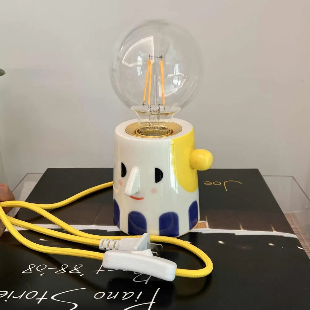 Handmade ceramic table lamp with ball headlight design on wooden surface