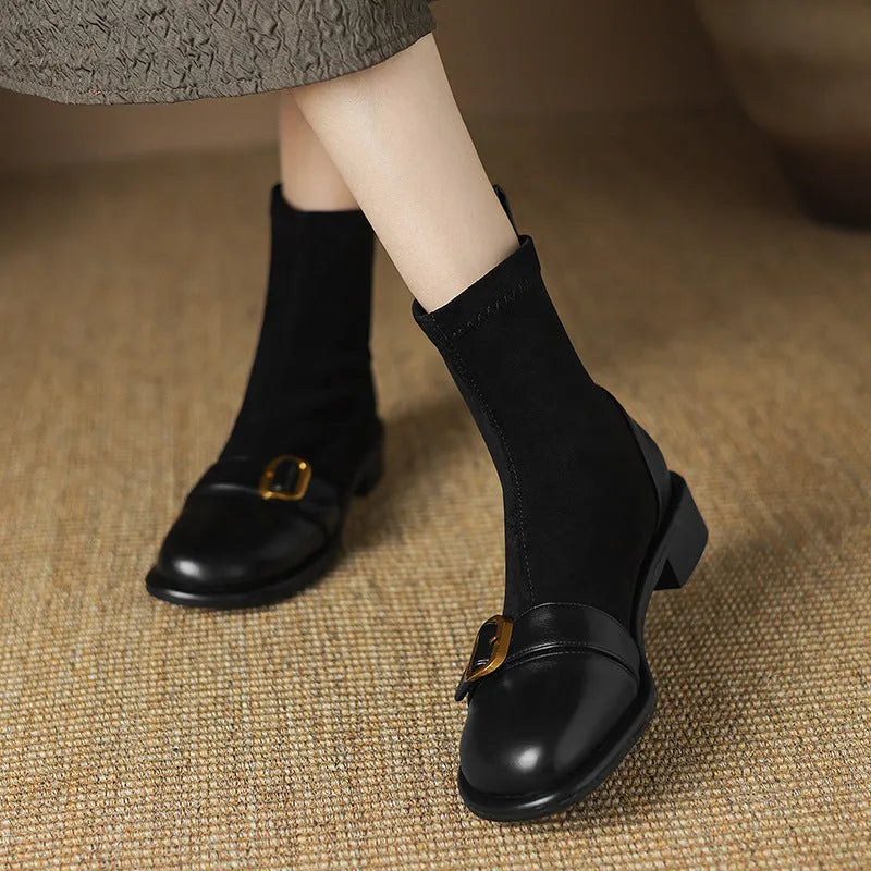 Women's black casual low-heel ankle boots with belt buckle detail and front lace-up closure.