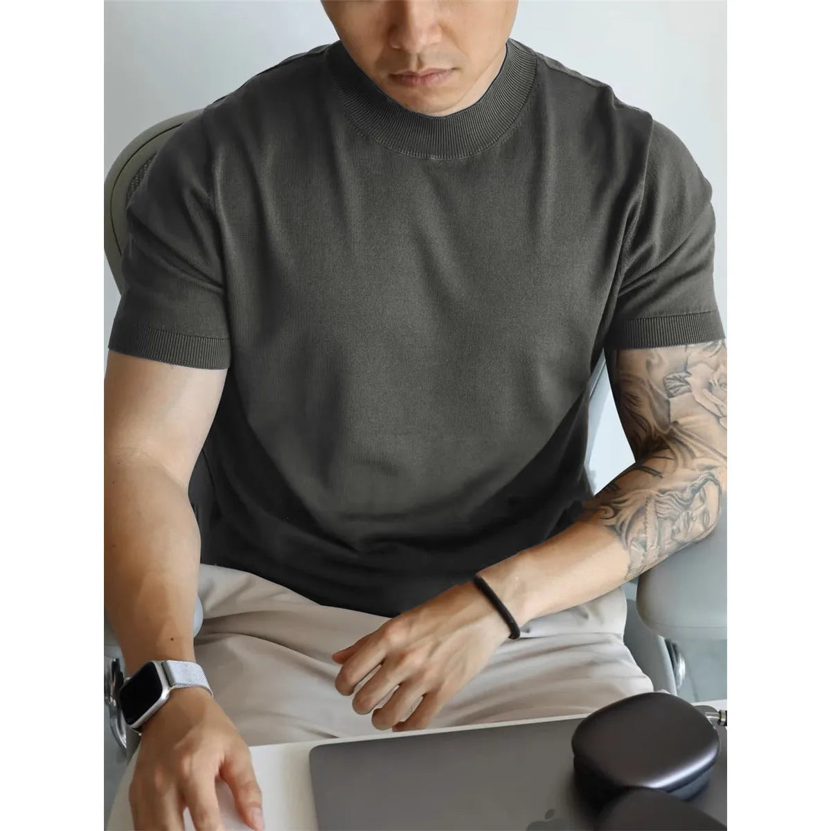Man wearing a slim-fit solid colour polyester t-shirt, showcasing its lightweight knitwear construction.