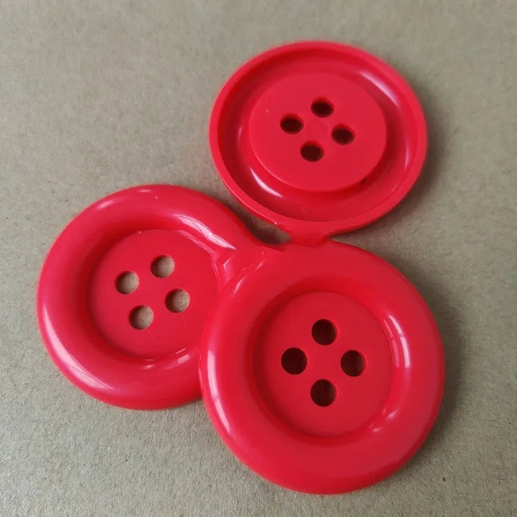 Oversized round plastic sewing buttons in multiple colours with four holes