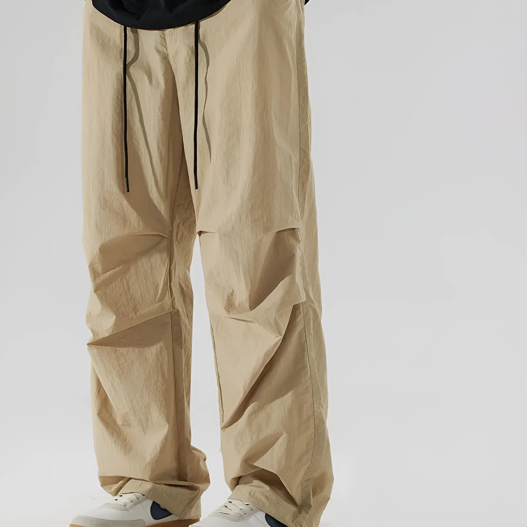 Man wearing loose straight-leg casual trousers in thin ice silk nylon fabric, showing apricot colour option.