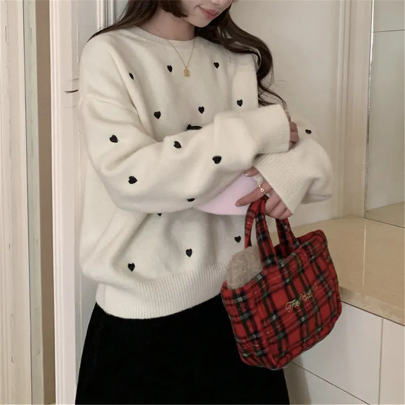 Women's loose fit acrylic pullover sweater with embroidered love pattern in milky white.