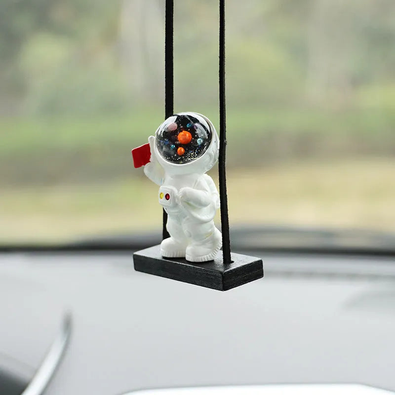 Resin cartoon astronaut car pendant available in red flag, telescope, and radish holding styles for dashboard decoration.