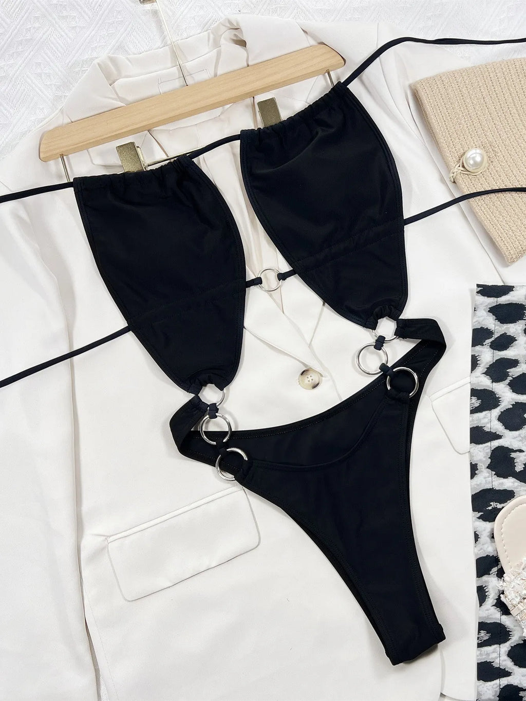 Black women's one-piece swimsuit on hanger showing sleeveless design