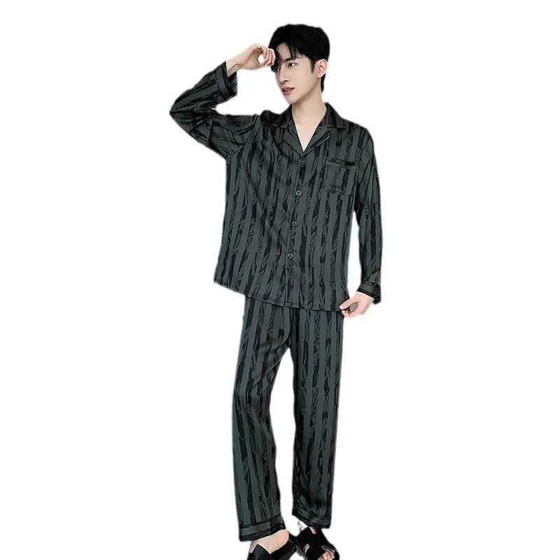 Men's black striped Ice Silk long sleeve V-neck pajama top and thin trousers set laid flat.