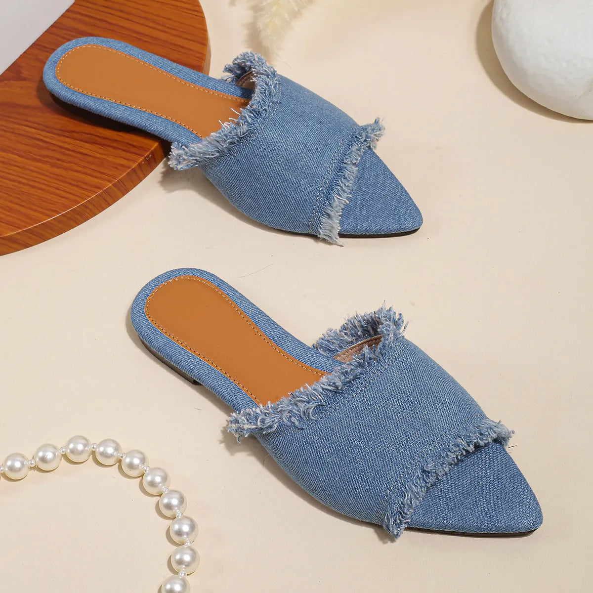 Women's denim flat slippers with a tassel, leather lining, and a PVC sole in various colours.