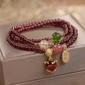 Purplish red rope bracelet with a detailed natural garnet fox pendant and adjustable tie closure.