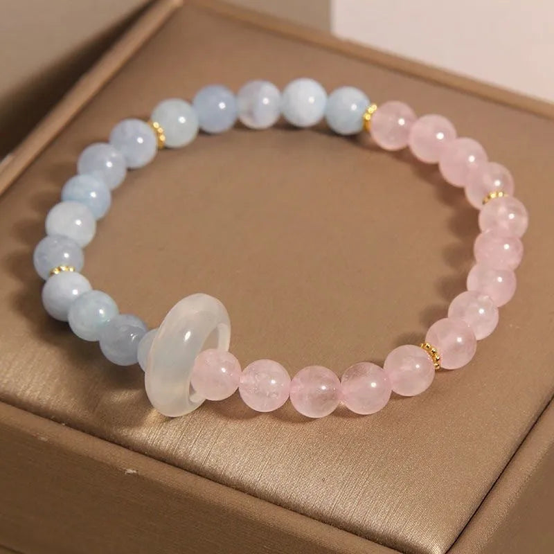 Aquamarine crystal bracelet with mixed materials including pink beads, white pearls, and peach blossom elements