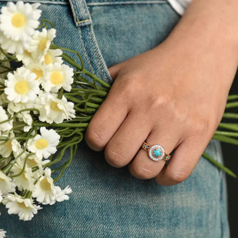 Women's rose gold coloured copper ring with geometric shape and inlaid turquoise zircon stones.
