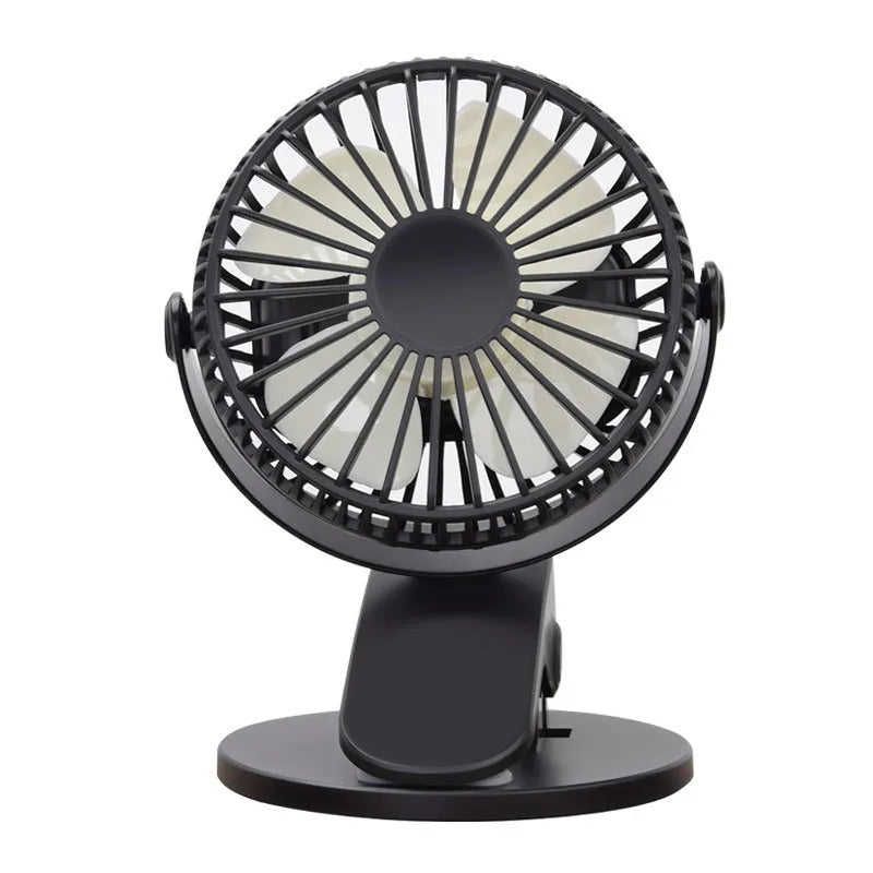 Small white clip fan with USB cable attached to a desk edge