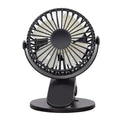 Small white clip fan with USB cable attached to a desk edge