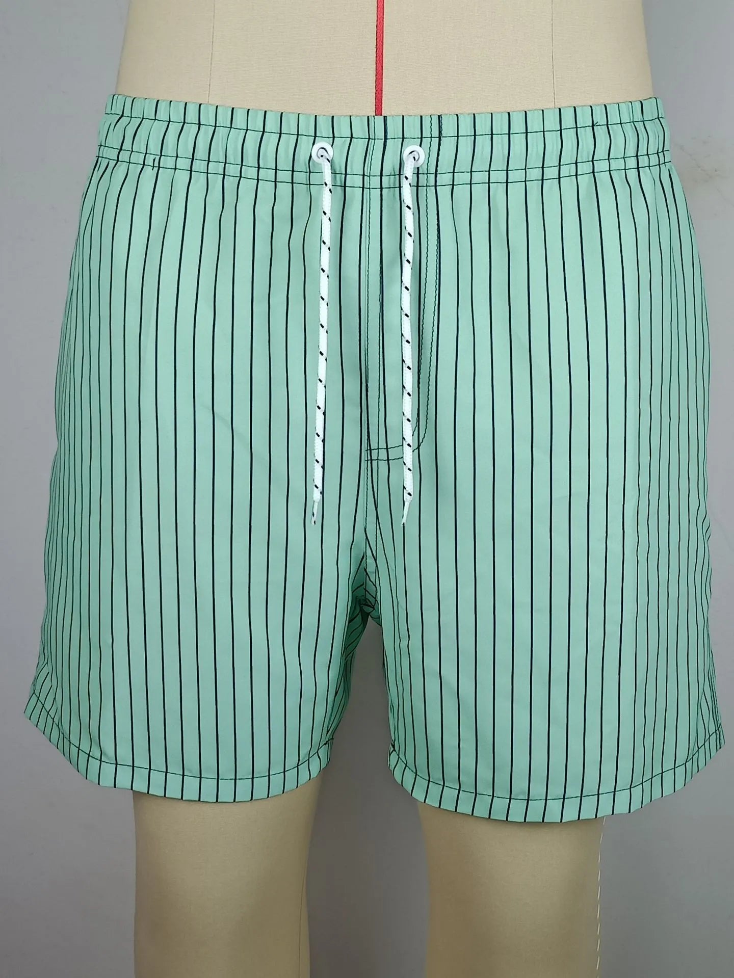 Polyester fibre beach shorts with digital printed striped triangle lining in straight leg style