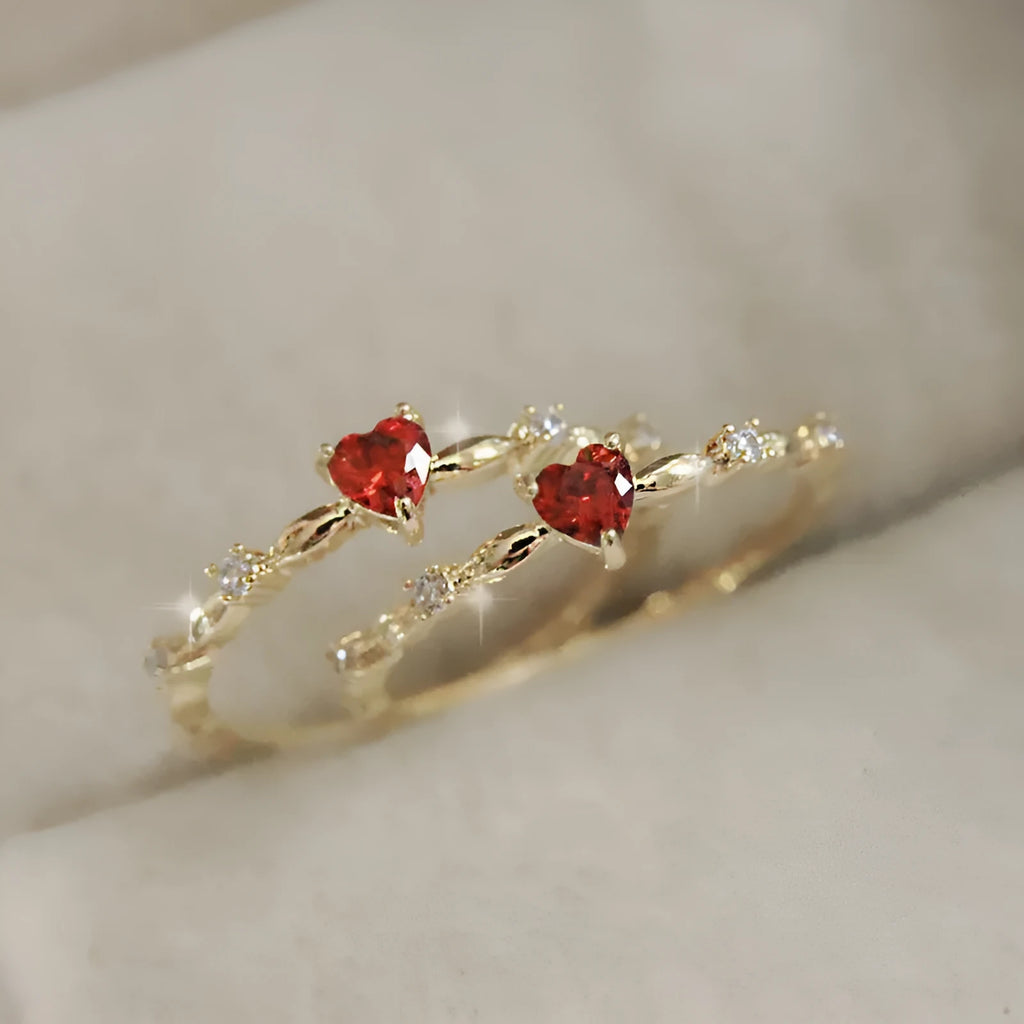 Gold tone peach heart ring with zircon stone centre on finger