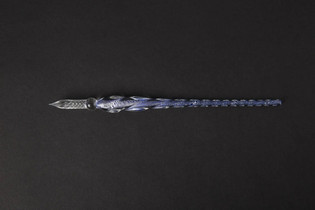 Hand-blown glass crystal pen with coloured ink in a transparent barrel on a gift box.